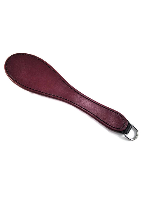 A small dark red leather spanking paddle packed with sting